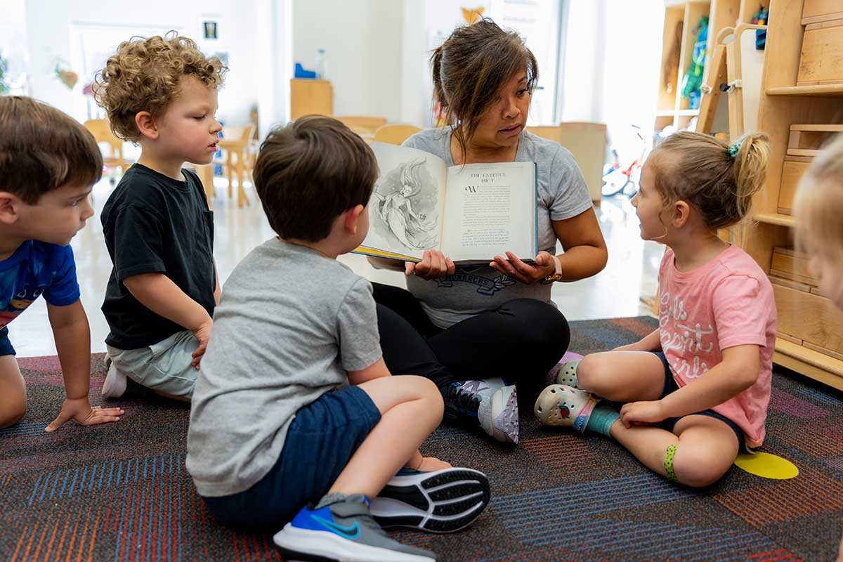 teacher reading book kids