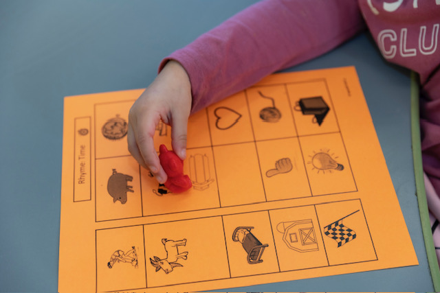 A child writes on paper with a pencil, focused on their task.